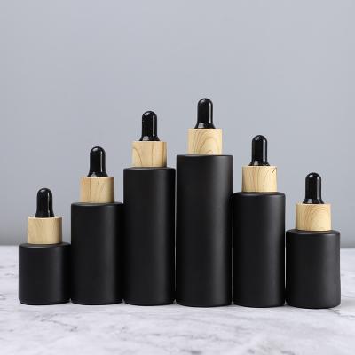 China Personal Care 20~100ml Matte Black Flat Shoulder Essential Oil Dropper Bottle Essence With Lid Forst Bamboo Glass Bottles Customization Logo for sale