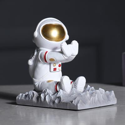 China Creative Waterproof Astronaut Resin Mobile Phone Seat Astronaut Doll Mobile Phone Holder Home Decoration Ornament for sale