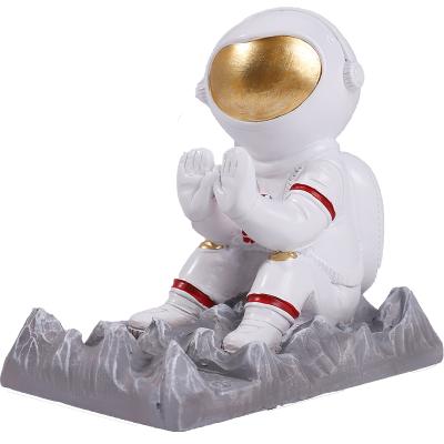 China Waterproof Mobile Phone Seat Resin Astronaut Mobile Phone Bracket Cartoon Astronaut Sitting Position Lazy Bracket for sale