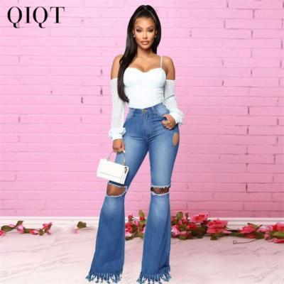 China Newest Design Breathable Mid-Waist Zipper Jeans Solid Color Ripped Irregular Side Street Style Flared Pants Women for sale