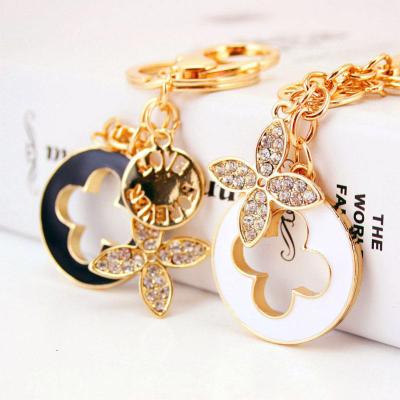 China Recycable Diamond Ladies Perfume Bottle Keychain Small Bag Accessories Metal Pendant Clover Key Chain Gift for sale