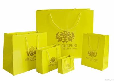 China Bolsa de papel impresa amarillo grande reciclable, bolsos del regalo con las manijas para promocional en venta