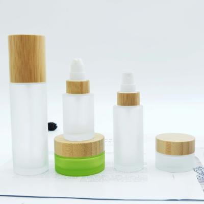 China 30ml 50ml 100ml 120ml 150ml Cosmetic Packaging Lid Natural Bamboo Glass Frosted Lition Spray Bottle With Pump for sale