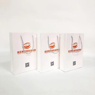 China Handmade Customize Logo Design Rugby Clothing Packaging Art Paper Bag With Twist Nylon handles for sale