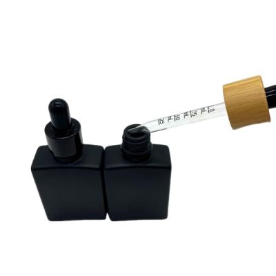 China 15ml 30ml 50ml 100ml cosmetic square black glass bottle with bamboo dropper for sale