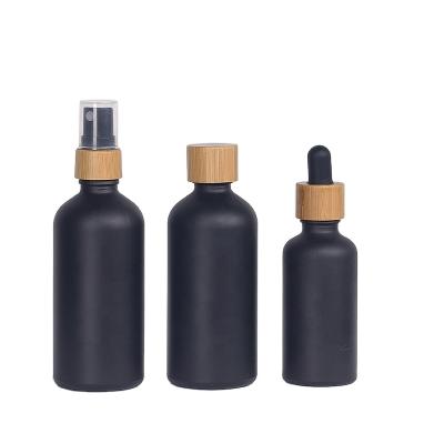 China 1oz 2oz 30ml 50ml 60ml 100ml Eco-friendly Matte Black Multi-function Matte Black Essential Glass Dropper Bottle With Lid Bamboo Top for sale