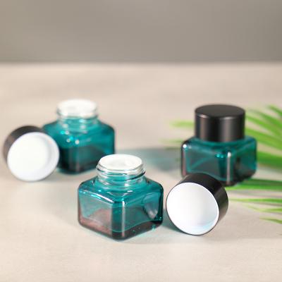 China Empty refillable cosmetic cream glass jars wholselar luxury cosmetic glass jar with deep black lid for sale