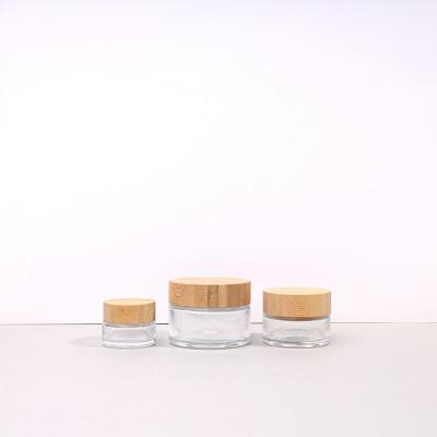 China Round 30ml Sample Glass Cosmetic Jar Skin Care Packaging Small Glass Eye Cream Jars With Wooden Cap for sale