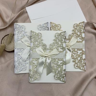 China Luxurious Europe Glitter Paper Laser Cut Wedding Invitation Card With Ribbon for sale