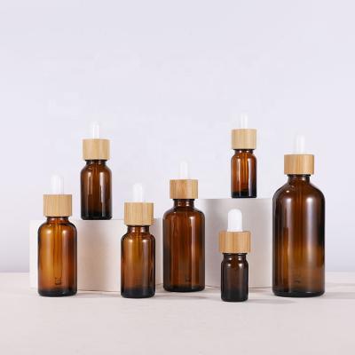 China Personal care 15ml 30ml 50ml frosted glass bottle amber packaging bottle with bamboo cap glass dropper bottle for sale