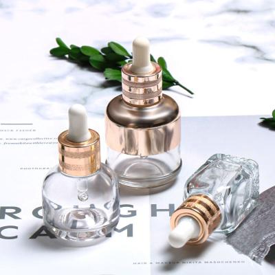 China Personal Care Essential Oil Glass Bottle Serum Glass Bottle Luxury Customization With Gold Shoulder Sleeve Dropper Glass Bottle for sale