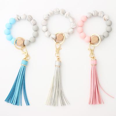 China 2021 New Key Chain Wristband Key Chain 2021 Logo Key Chain Silicone Bead Wristband Custom Wood Leather Wrist Plastic Colorful Tassel for sale