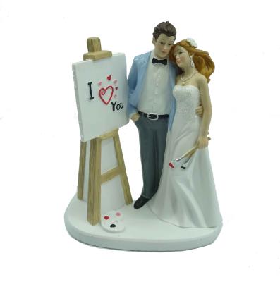 China Topper Polyresin Cake Topper Romantic Wedding Couples Figurine With Drawing Board for sale