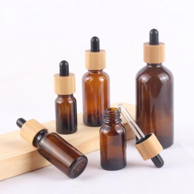 China Clear Glass Skin Care Bottle Packaging Personal Wooden Hat Bamboo Amber And Blue Green Dropper Bottle 30ml Essential Oil Glass Bottle for sale