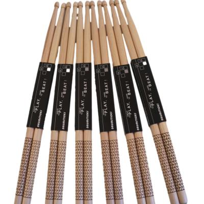 China Popular Wholesale Percussion Accessories 5A Drum Sticks Natural Wood Color Engraved Texture Laser Logo Anti-Slip Hickory Drumstick for sale