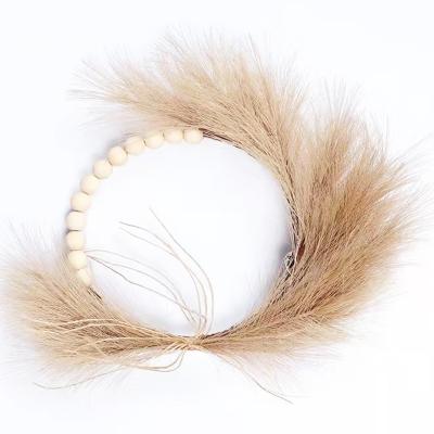 China Warm Wedding Decor Garland Wedding Amazon Design Artificial Pampas Grass Wreath With Wooden Beads Tassel For Home Wedding Decoration for sale