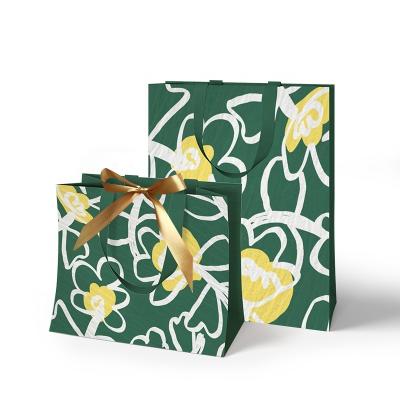 China Custom Recycled Materials Logo Luxury Gift Clothing Paper Shopping Bags With Ribbon for sale