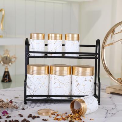 China Eco-Friendly Luxury Gold Cylinder Container White Cereals Sugars Kitchen Storage Seasonings Jars Set Ceramic Jam Cookie Canning Jar With Lid for sale