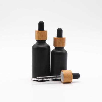 China Pharmaceutical Liquid Bottle 30ml Luxury Bamboo Lid Essential Oil Black Matte Glass Dropper Bottle E e Juice Ready To Ship for sale