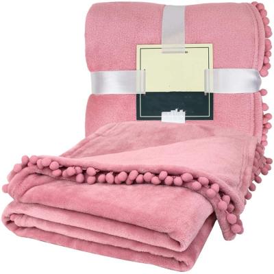 China PORTABLE plain dyed soft fashion flannel fleece blanket with tassels pom pom blankets for sale