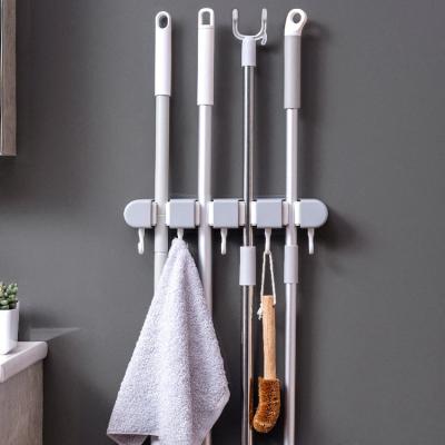 China Wall Mounted Multifunctional Hanging Broom Broom Holder Strong Hook Punch Free Minimalist Plastic Holder for sale