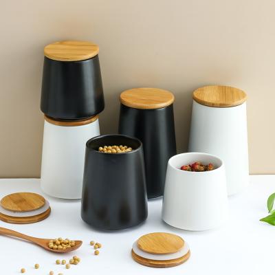 China Heatable Ceramic Black White Kitchen Food Storage Bottles And Storage Jars Pot With Bamboo Lid for sale