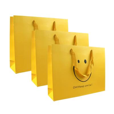 China Wholesale Recyclable Mailing Bag Paper Tote Bags Cartoon Smiling Face Cartoon Paper Bag for sale