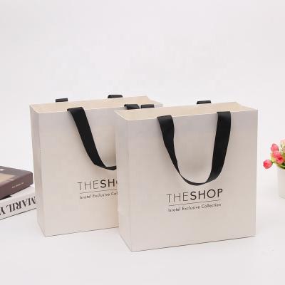 China Recyclable Custom Luxury Apparel Packaging T-shirt Shoes Gift Boutique Ivory Paper Shopping Bags With Ribbon Handle for sale