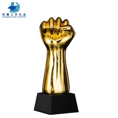 China China Dongying Resin Fist Shape Wholesale Gold Trophy With Black Base for sale