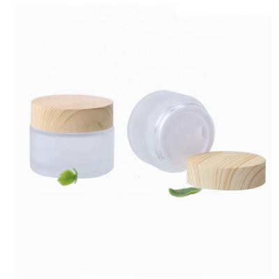 China Eco - Friendly Frost Empty Cosmetic Cream Glass Jars With Wooden Lid 50G for sale