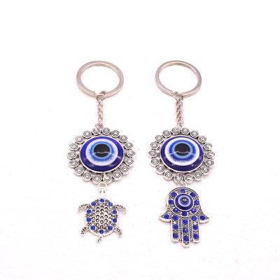 China New Fashion Metal Base Alloy Pendant Bags Resin Hamsa Keychains Evi Eye Key Chains Key/Pendant Bags/Gift Key Chains Bags for sale