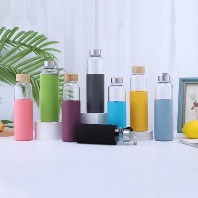 China 550ml Eco-Friendly Sustainable Borosilicate Transparent Bamboo Lid Glass Drinking Water Bottle With Silicone Sleeve for sale