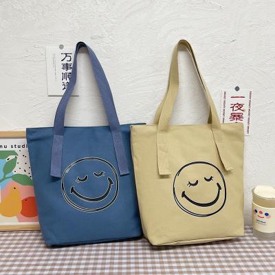 China Fashion student canvas bag small face shoulder tote bag class school support female simple cute smile female portable bag one for sale