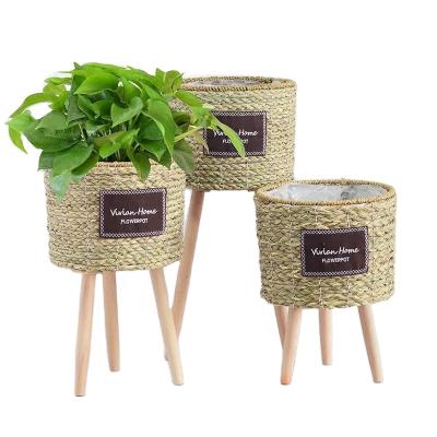 China Handmade Water Hyacinth Planter Basket with Stand Straw Tin Flower Pot with Leg for Living Room for sale