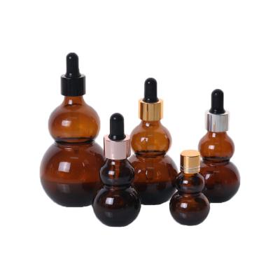 China High Quality Wholesale Cosmetic Amber Glass Dropper Bottles Flat Essential Oil Perfume Packaging Gourd Glass Bottle for sale