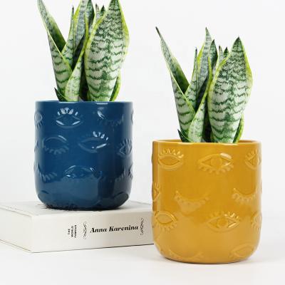 China Modern Embossed Eyes Design Cylindrical Flowerpot Ceramic Planter Pot For Home Decor for sale