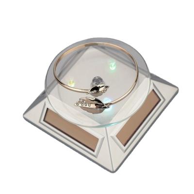 China Solar Powered 360 Rotating Geometric Turntable Display Showcase Led Light Jewelry Display Stand for sale