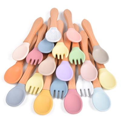 China High Quality Cute Mini Baby Feeding Spoon Bpa Free Wooden Handle Soft Tips Silicone Spoon and Fork Stocked Set for sale