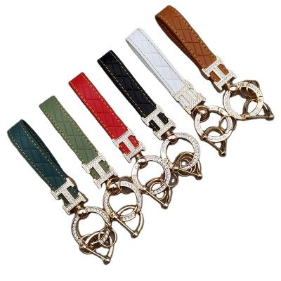 China Leather Exquisite and fashionable diamond shaped high-end leather rope embossed diamond car keychain for sale