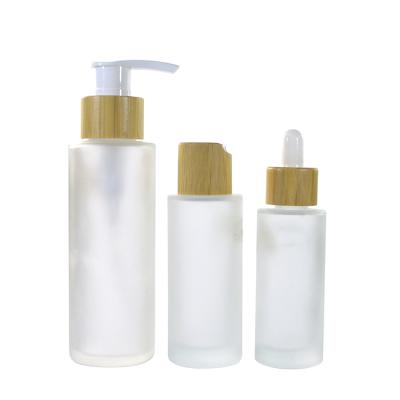 China Clear Frosted Cosmetic Set 30ml 50ml 100ml 120ml 150ml Cosmetics Glass Cosmetic Packaging Bottle With Bamboo Lid for sale