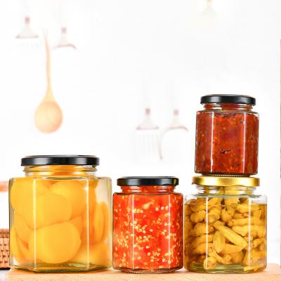 China Food High Quality Customized Hexagon Shape Glass Jar for Honey Jams Food Storage with Lid for sale