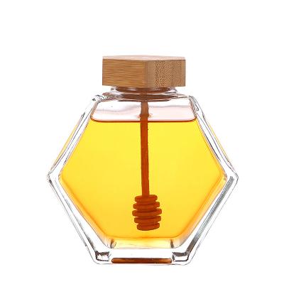 China Honey Spot High-Grade Hexagonal Wood Honey Jar Cover with Stirring Rod Glass Jars For Honey for sale