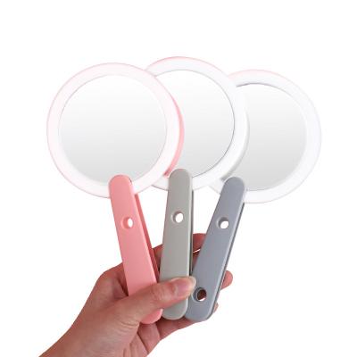 China 2022 Hot Tour Lighted Shape Led Cosmetic Mirror With LED Light Strip Cosmetic Holder With Foldable Handle Makeup Mirror For Girls for sale