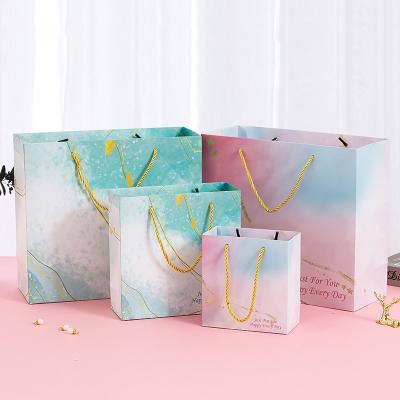 China Custom Recyclable Luxury Colorful Paper Garment and Cosmetics Gift Packaging Bag Logo Wedding Favor Gift Packaging Box With Handle for sale