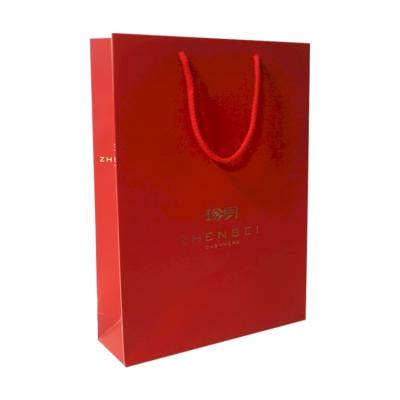 China Best Selling New Design Debossed Embossingtexture Stain UV Surface Finished Red Paper Bag Recyclable for sale