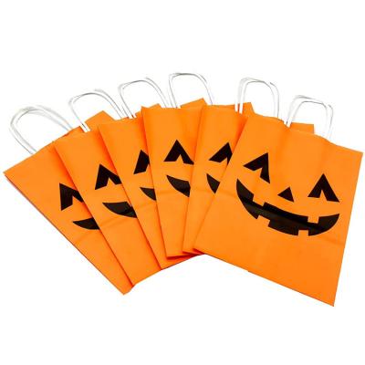 China Recycled Materials Pumpkin Face Kraft Paper Bag Christmas Halloween Candy Handle Bag for sale