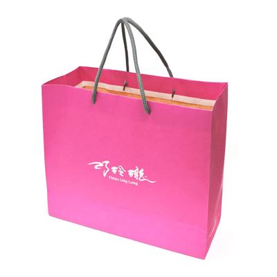 China Handmade cosmictic paper clothing bag with ribbon for sale