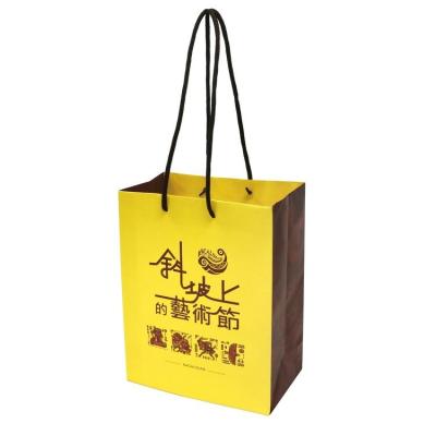 China Recyclable Luxury Yellow Shopping Paper Bag With Logo For Apparel Packaging for sale