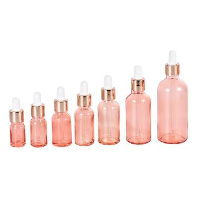 China OEM RTS cosmetic glass dropper bottle light pink shinny gold prime glass dropper bottle with customized logo printing 5ml-100ml for sale