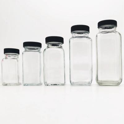 China Eco - Friendly Glass Spices Jars With Plastic Lids , Clear Square Water Bottles Juice Milk Beverages With Cap for sale